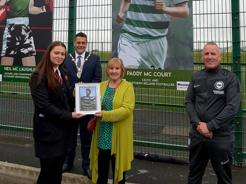 Celine McCourt receives a photograph of her son Paddy McCourt’s sporting hero mural on display at the Leafair Well-Being Village from St Brigid's College pupil Jenna Patton. Included in the photograph are Leroy McCourt and the Mayor of Derry and Strabane Alderman Graham Warke. DER2125GS - 019