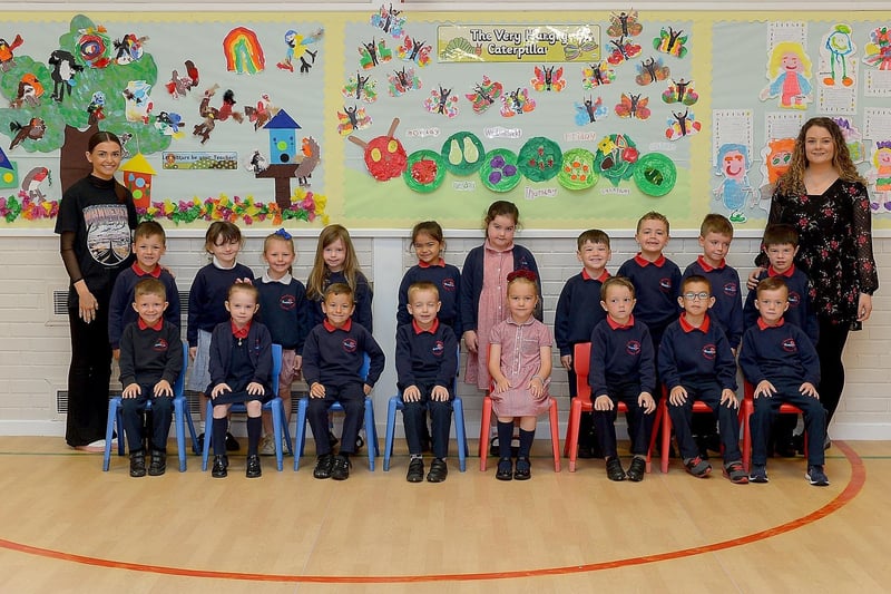 Miss Coyle, teacher (on the right) and Miss Lynch, classroom assistant, pictured with St Oliver Plunkett Primary School’s P1 class and classroom assistants.  DER2123GS – 024