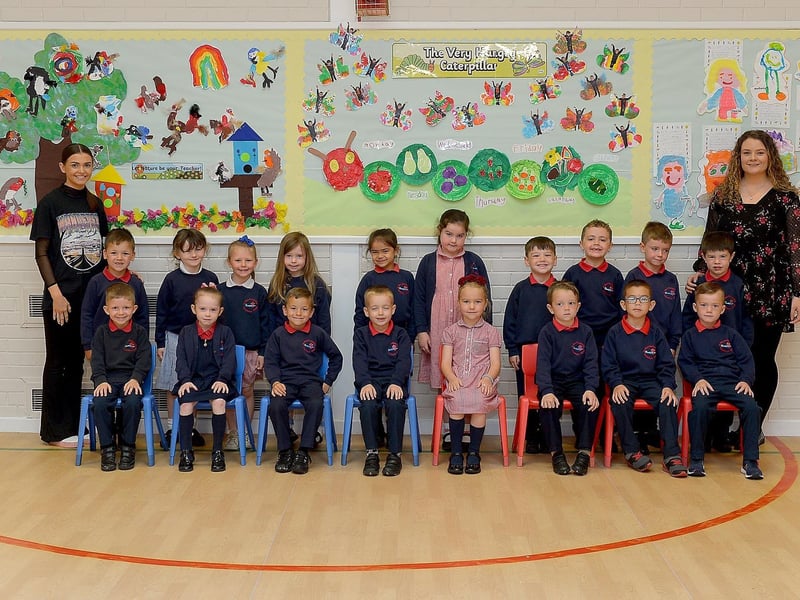 Miss Coyle, teacher (on the right) and Miss Lynch, classroom assistant, pictured with St Oliver Plunkett Primary School’s P1 class and classroom assistants.  DER2123GS – 024