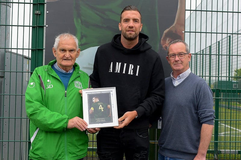 Gerry Doherty and Eddie Breslin, NIHE, project sponsor, present Shane Duffy with a photograph of Shane’s sporting hero mural on display at the Leafair Well-Being Village. Photos: George Sweeney / Derry Journal DER2125GS - 023