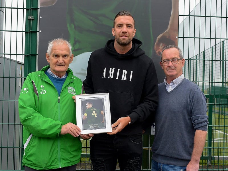 Gerry Doherty and Eddie Breslin, NIHE, project sponsor, present Shane Duffy with a photograph of Shane’s sporting hero mural on display at the Leafair Well-Being Village. Photos: George Sweeney / Derry Journal DER2125GS - 023