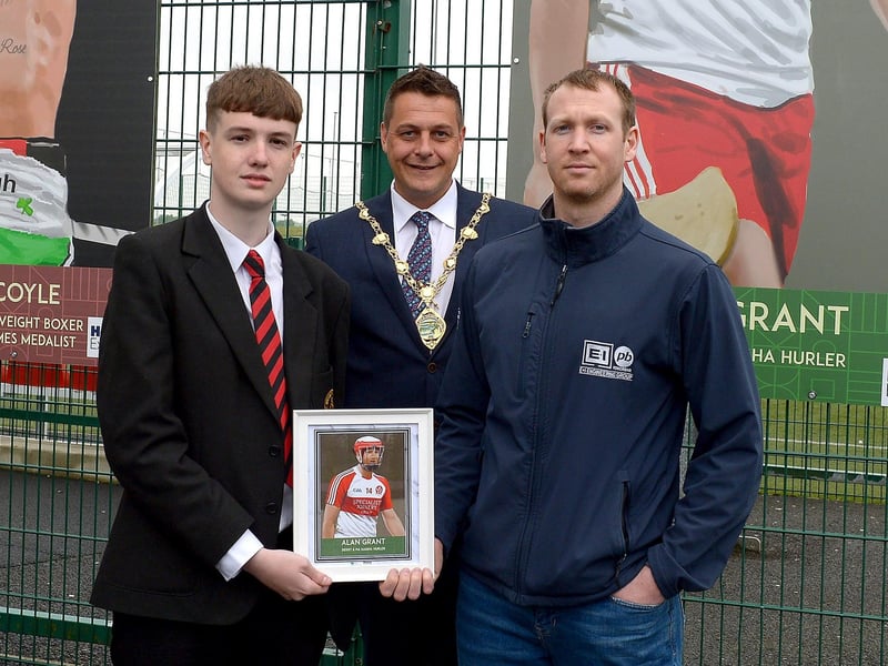 Tiarnan Quigley, St Brigid’s College, and the Mayor of Derry and Strabane Graham Warke present Na Magha’s Alan Grant with a photograph of Alan’s sporting hero mural on display at the Leafair Well-Being Village. DER2125GS - 026