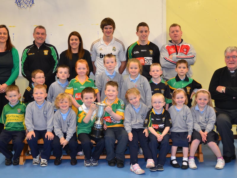 O'Brien's Foreglen club chairman Noel McFeely and senior players Eoighan Duffy and Eunan McFeely, with backroom management member Damien O'Connor pictured with the Intermediate Championship Trophy proudly displayed by the P1/P3 pupils at St. Peter's and St. Paul's Primary School, Foreglen on Friday morning. Also pictured is their class teacher, Mrs. Fiona McCann (Principal) and Rev. Fr. Art O'Reilly. DER4313JM001