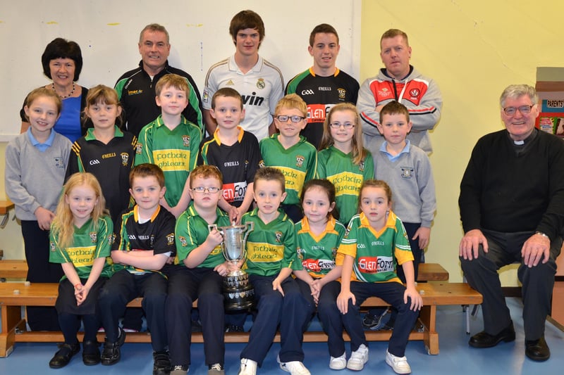O'Brien's Foreglen club chairman Noel McFeely and senior players Eoighan Duffy and Eunan McFeely, with backroom management member Damien O'Connor pictured with the Intermediate Championship Trophy proudly displayed by the  P4/P5 pupils at St. Peter's and St. Paul's Primary School, Foreglen on Friday morning. Also pictured is their class teacher, Mrs. Fiona McCann (Principal) and Rev. Fr. Art O'Reilly. DER4313JM002