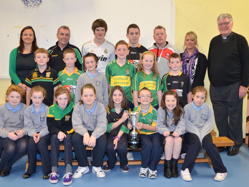 O'Brien's Foreglen club chairman Noel McFeely and senior players Eoighan Duffy and Eunan McFeely, with backroom management member Damien O'Connor pictured with the Intermediate Championship Trophy proudly displayed by the  P6/P7 pupils at St. Peter's and St. Paul's Primary School, Foreglen on Friday morning. Also pictured is their class teacher, Mrs. Fiona McCann (Principal) and Rev. Fr. Art O'Reilly. DER4313JM003