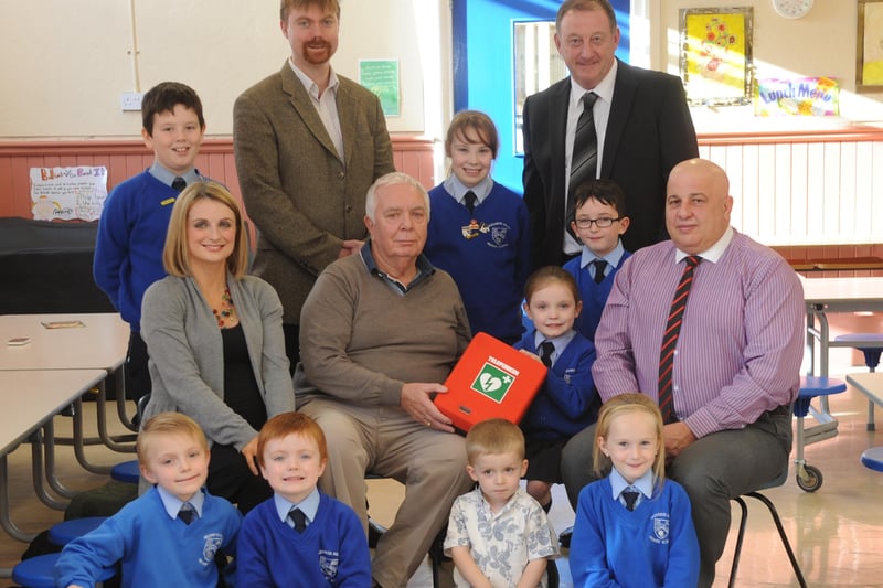 Hannah Deery and her grandfather, Edgar McCormick ,pictured with some of the children at the presentation of a Defibrillator to the Nazareth House Primary School. Included, are  Paul O'Hea, principal and Dr Ciara McLaughlin and Dr joe Devlin and Ron Higgins, supplier, Nor-chem. DER4313SL001