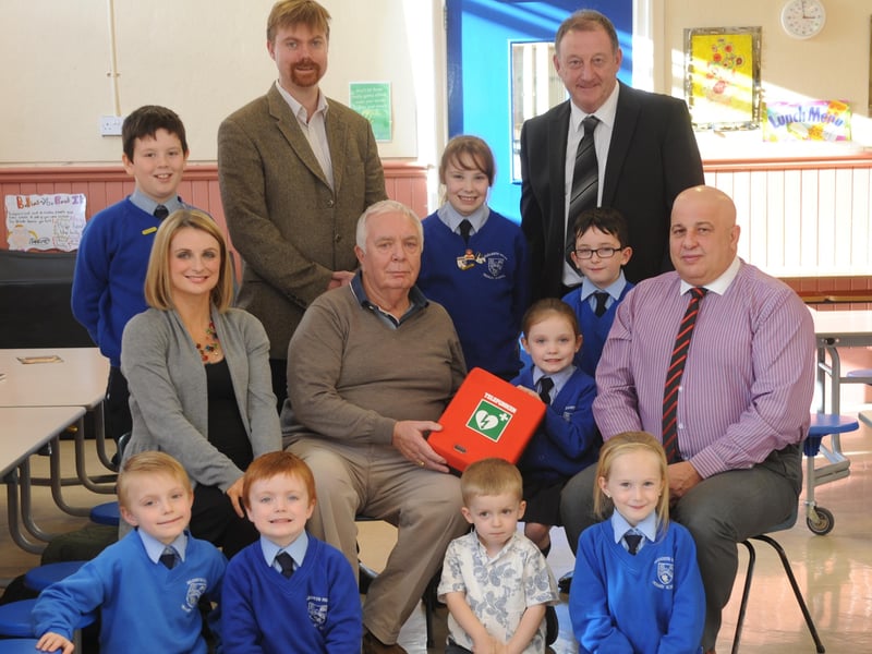 Hannah Deery and her grandfather, Edgar McCormick ,pictured with some of the children at the presentation of a Defibrillator to the Nazareth House Primary School. Included, are  Paul O'Hea, principal and Dr Ciara McLaughlin and Dr joe Devlin and Ron Higgins, supplier, Nor-chem. DER4313SL001
