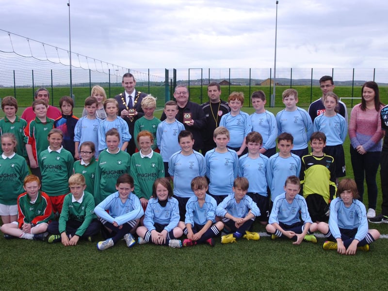 The Mayor of Derry Colr. Martin Reilly presents trophies to pupils from Bunscoil Colmcille and Hollybush Primary School taking part in the finale of the Outer North Primary School League at Leafair 3G Pitch. Included, from left, are Ciara Ferguson, GSAP, Peter McDonald, Leafair Community Association, Colr. Tony Hasson, referee Darren McDonald, Michaela McGilloway, second right, organisor, and coach Gareth Ryan. (2106PG77)