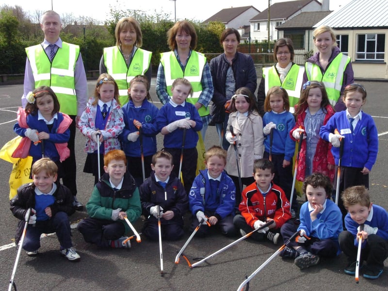 Children from Termoncanice Primary School clean up around the school grounds as part of their green flag preparations. Included, back row from left, are John McCarron, waste management officer, Mary Harron, vice principal, Zita McLaughlin, Linda Kelly Tosh, Sharon Harkin and Una Carton. (0305PG28)