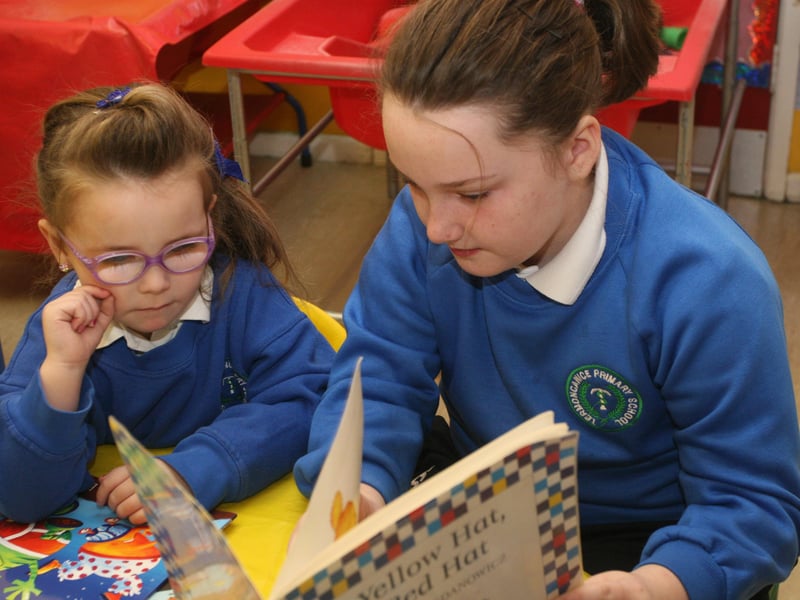 Termoncanice PS P6 pupil Kerri McGonigal helps nursery pupil Brooke, yesterday morning. 2802JM15