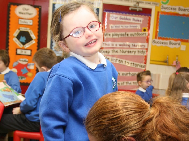One of the young nursery pupils takes time out to get her lace tied by P6 teacher, Ms. Toner, during yesterday morning's 'Book Buddies' at Termoncanice PS. 2802JM14
