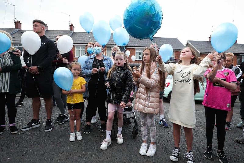 Local children release blue balloons into the air.