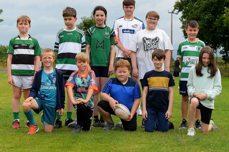 Ross McLaughlin, City of Derry Rugby Club, pictured with some of the boys and girls who took part in the recent sports camp at Broadbridge Primary School.  DER2130GS - 060 (Picture by George Sweeney)