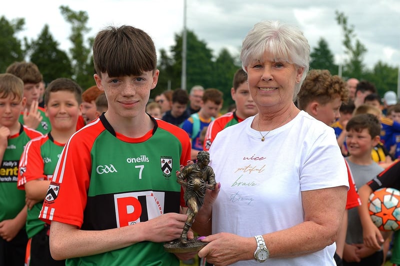 Doire Trasna captain Callum Downey receives the 'Player of the Tournament' trophy from Pat McChrystal at the John McChrystal U13 tournament. Photo: George Sweeney. DER2121GS – 101
