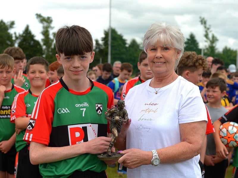 Doire Trasna captain Callum Downey receives the 'Player of the Tournament' trophy from Pat McChrystal at the John McChrystal U13 tournament. Photo: George Sweeney. DER2121GS – 101