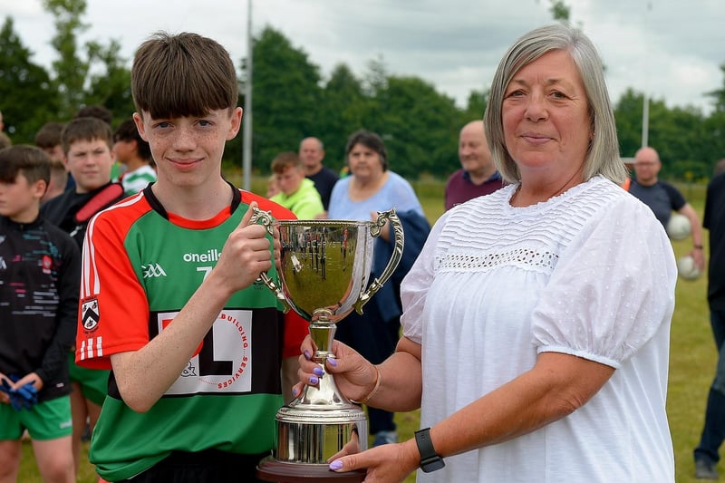 Doire Trasna captain Callum Downey receives the John McChrystal Cup from Jeanette McChrystal on Saturday afternoon last. Photo: George Sweeney. DER2121GS – 099
