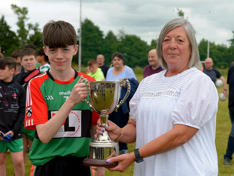 Doire Trasna captain Callum Downey receives the John McChrystal Cup from Jeanette McChrystal on Saturday afternoon last. Photo: George Sweeney. DER2121GS – 099