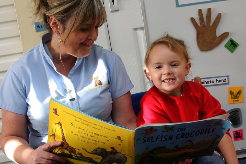 Evelyn Catterson, reading a story to Jodi Pollock, at the Drumahoe Community Playgroup which reopened after it was badly damaged in an arson attack during the summer.  LS4010-557MT.