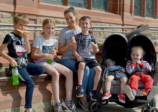 The McLaughlin family relax in the sunshine and warm temperatures in Guildhall Square yesterday afternoon. DER2134GS – 029