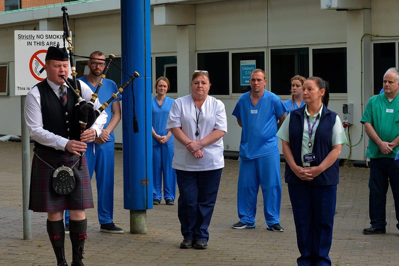 A piper plays a lament as care staff from Altnagelvin hospital take part in an Act of Remembrance for all who have lost their battle with COVID-19, on Thursday evening last.  DER2020GS – 026