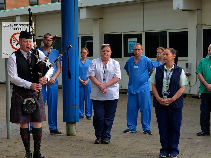 A piper plays a lament as care staff from Altnagelvin hospital take part in an Act of Remembrance for all who have lost their battle with COVID-19, on Thursday evening last.  DER2020GS – 026