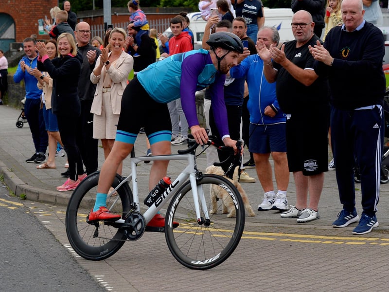 Ironman triathlon hero Danny Quigley is greeted by supporters and well-wishers as he arrives at Destine’s premises, Foyle Road, on Sunday afternoon after completing his tenth and final daily 112 mile cycle before setting off on his final 26.2 miles run to complete 10 triathlons in 10 days. Photo: George Sweeney / Derry Journal. DER2135GS – 003