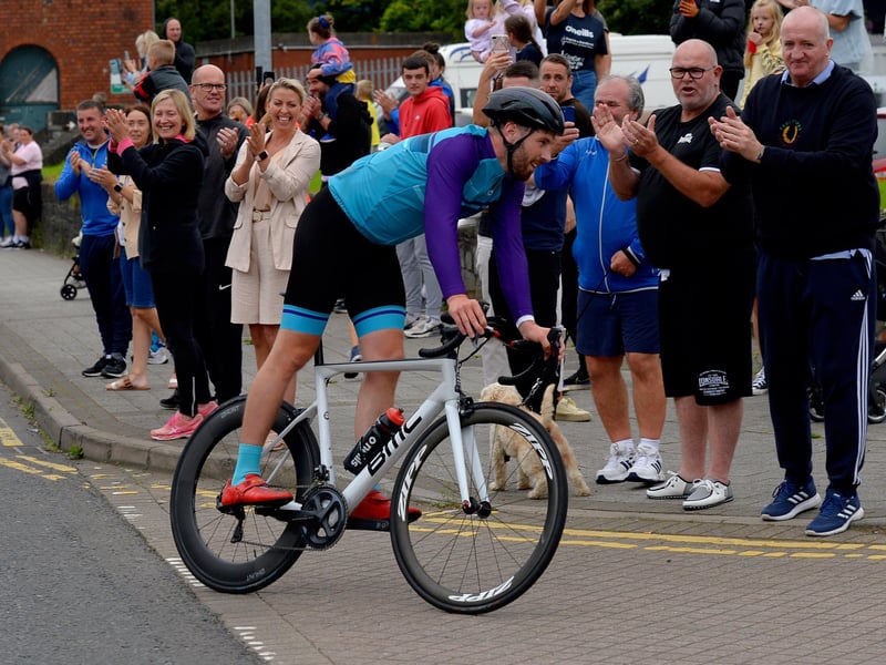 Ironman triathlon hero Danny Quigley is greeted by supporters and well-wishers as he arrives at Destine’s premises, Foyle Road, on Sunday afternoon after completing his tenth and final daily 112 mile cycle before setting off on his final 26.2 miles run to complete 10 triathlons in 10 days. Photo: George Sweeney / Derry Journal.  DER2135GS – 003