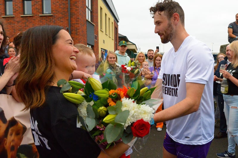Sporting hero Danny Quigley presents his partner Emear with flowers on his arrival at Destined after completing a gruelling 10 Ironman Triathlons in 10 days in memory of his dad and fundraising over 74,000 for charities.  Photo: George Sweeney / Derry Journal.  DER2135GS – 026