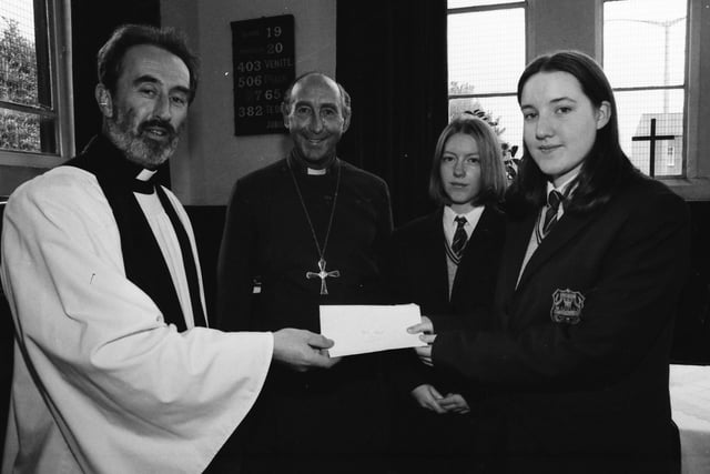 Thornhill pupils, from right, Louise Doherty and Christine McCauley, handing over a cheque of £800 to Rev. Donald McClean, whose church was damaged by fire. Included is Rev. Dr. James Mehaffey, Bishop of Derry and Raphoe.