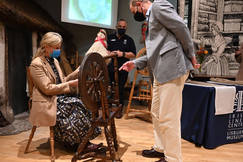 The Countess of Wessex embraces the opportunity to try the spinning wheel while The Earl of Wessex studies how it works.
