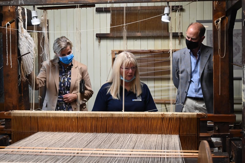Alison one of the weavers at the Irish Linen Centre and Lisburn Museum demonstrates one of its looms to their Royal Highnesses.