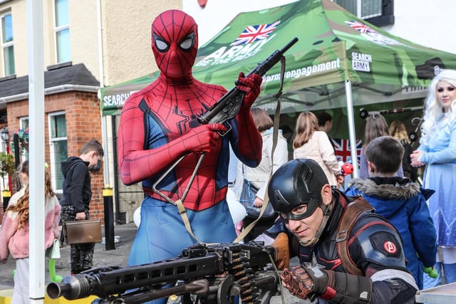 Spiderman and Captain America trying out the weapons on display