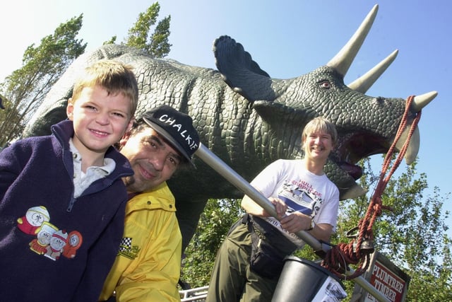 Michael Hayward, aged four years, of Moss, is pictured with Ian 'Chalkie' White and Chris Horan. Michael came out to look at the dinosaur as it passed his home on its way to Stainforth.