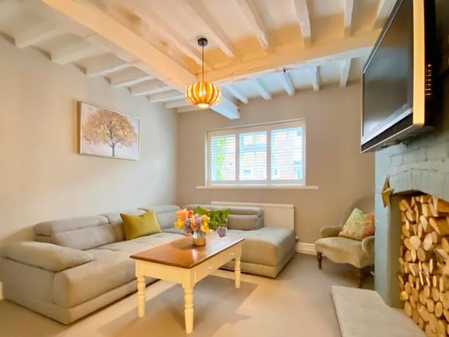 Cosy comfort is the key to the sitting room or snug, which also has space for a desk. There are double-glazed windows to the front, window shutters and a beamed ceiling.