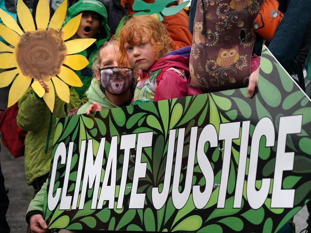 Climate Justice Activists at the Cop26 Gates asking delegates as they make final decisions, "Are You With Us Or With Fossil Fuels?" during the official final day of the Cop26 summit in Glasgow. Picture date: Friday November 12, 2021.