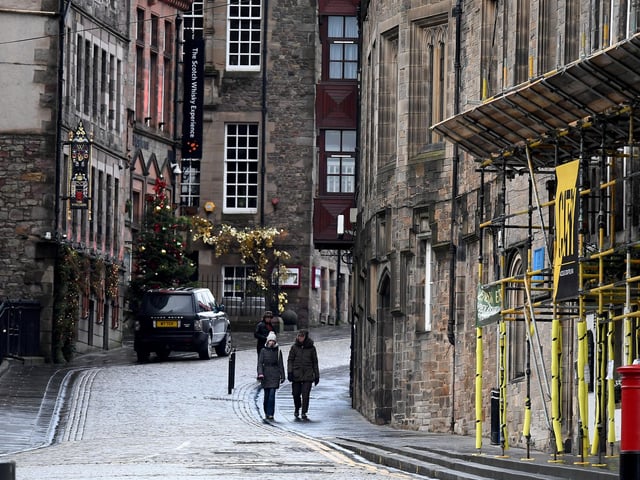 Members of the public walk through a deserted Edinburgh City Centre on January 4, 2021