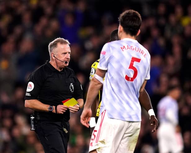 Manchester United's Harry Maguire (right) is sent off by referee Jonathan Moss after being shown a second yellow card during the Premier League match at Vicarage Road, Watford.