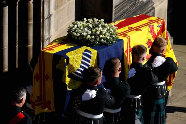 Pallbearers carry the coffin of Queen Elizabeth II from St Giles' Cathedral in Edinburgh on September 13, 2022 to a hearse to be transported to Edinburgh airport. - Charles III on Tuesday made his maiden visit to Northern Ireland as king, as he tours all four nations of the United Kingdom before next week's state funeral of his mother Queen Elizabeth II. The casket will be flown on Tuesday evening to London, where huge crowds are expected to pay their respects as she lies in state from Wednesday evening until her funeral on Monday morning. (Photo by Odd ANDERSEN / AFP) (Photo by ODD ANDERSEN/AFP via Getty Images)