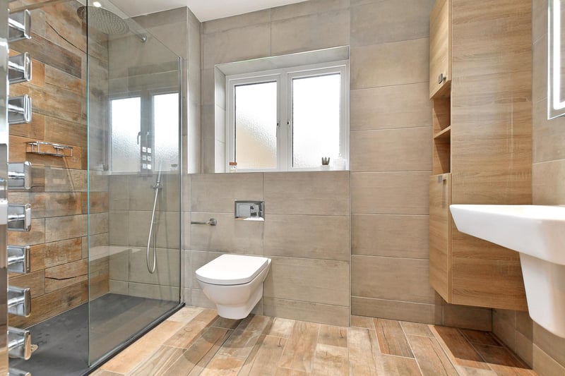 The master en-suite bathroom is fully tiled, has a chrome heated towel rail and under floor heating. There’s a suite in white, with a Roca chrome mixer tap, illuminated vanity mirror and fitted storage to each side. It also has a separate large walk-in shower enclosure with a fitted Abode rain head shower, an additional hand shower facility and a glazed screen.
