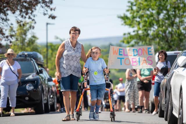 Nine-year-old Tobias Weller, from Sheffield, who has cerebral palsy and autism, completes the final leg of a 26.2 mile total of a walk he has called his "ginormous challenge", to walk a marathon using his walker during the lockdow (photo: Joe Giddens/PA Wire).