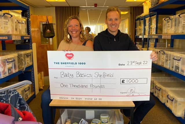 Dan Walker presents a cheque for £1,000 to Baby Basics CEO Sheffield on behalf of The Sheffield 1000 charity, which the TV presenter helped to set up