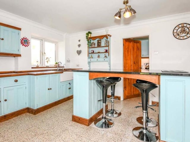 The traditional kitchen features an island, an alcove with feature brick and old beams, and a fully-working Aga. There is also a Belfast sink and a mixture of granite and wooden worktops. Nearby are a laundry room and a utility room.