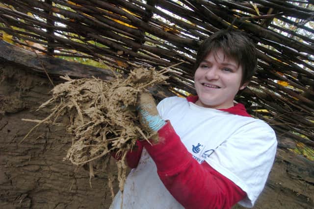 Sally Rodgers gets muddy at Heeley City Farm finishing the walls of a replica Iron Age roundhouse with a mixture of clay, sand and straw