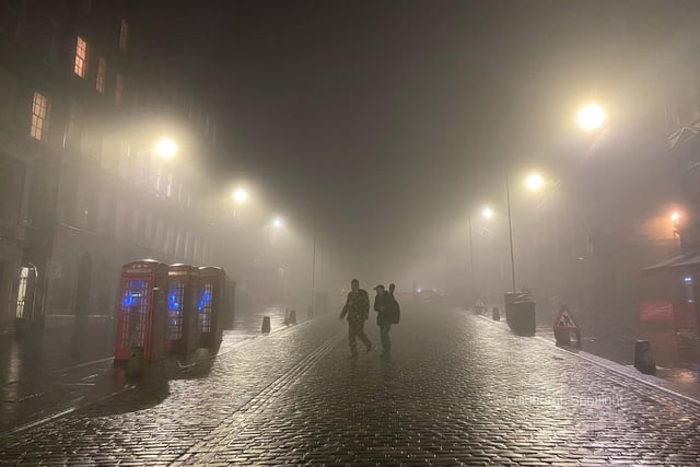 Two people making their way across Edinburgh's iconic Royal Mile as the city took up the spooky mantle of a horror film scene last night.