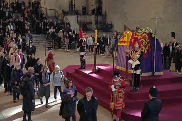 People view the coffin of Queen Elizabeth II, lying in state on the catafalque in Westminster Hall, at the Palace of Westminster, London, ahead of her funeral on Monday. Picture date: Sunday September 18, 2022. PA Photo: Jacob King/PA Wire