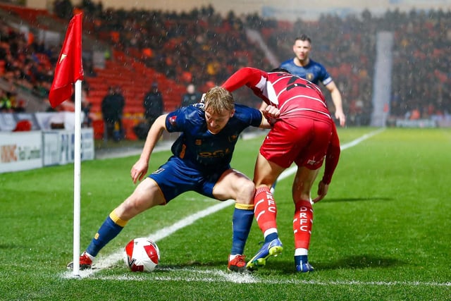 Mansfield Town midfielder George Lapslie holds off the Doncaster defender.