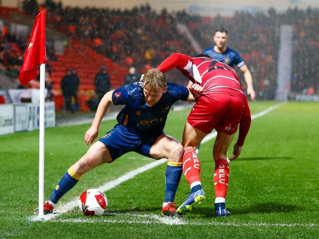 Mansfield Town midfielder George Lapslie holds off the Doncaster defender.