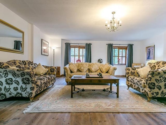 Moving inside the cottage, the hub is this large and well-proportioned sitting room. It boasts a log burner and a set of beautiful French doors that lead to a side courtyard.