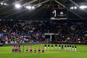 Swansea City and Sheffield United players, officials and fans observe a minute's silence in memory of Queen Elizabeth II: David Davies/PA Wire.