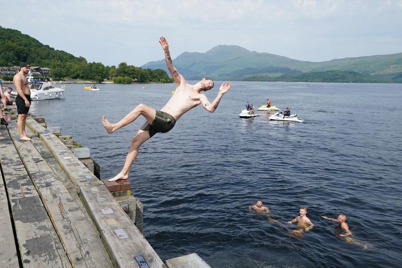 Luss offers great hiking trails as well as plenty of opportunity for loch-front summer fun. Pictured here are swimmers jumping into Loch Lomond from a pier in Luss. Picture: Andrew Milligan/PA Wire
